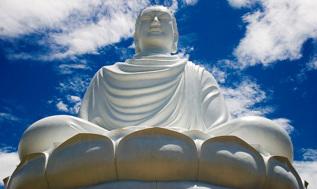 Eine riesige Buddha Statue thront auf einer Lotusblüte
